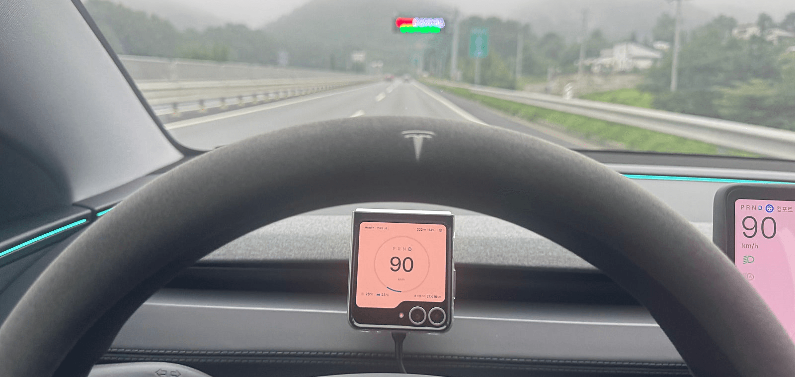 테슬라 운전대 사이의 작은 플립 커버 화면에 Tesdrive 속도계가 표시된 실제 주행 모습